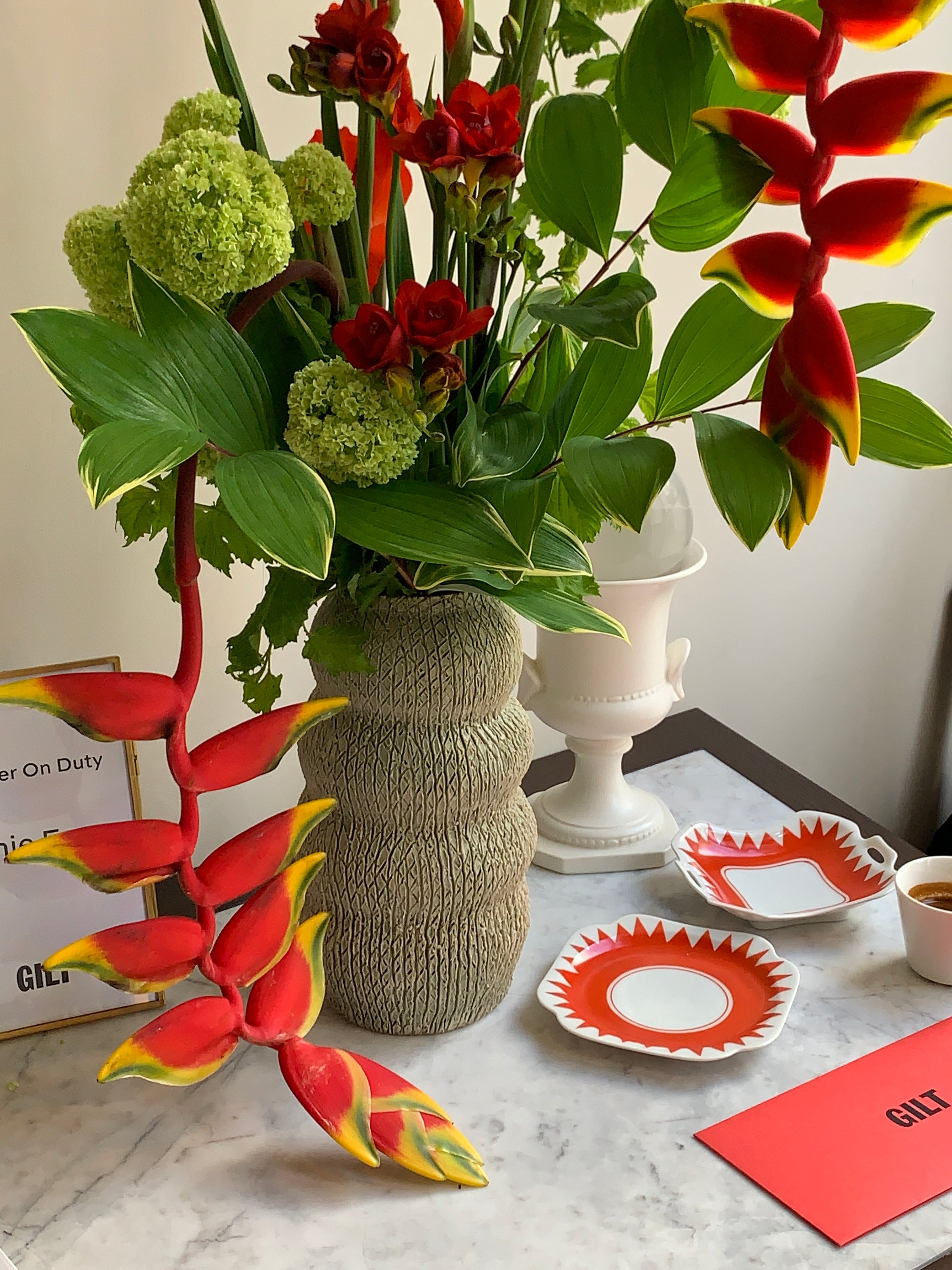 Bouquet of flowers with red and green leaves on a white surface