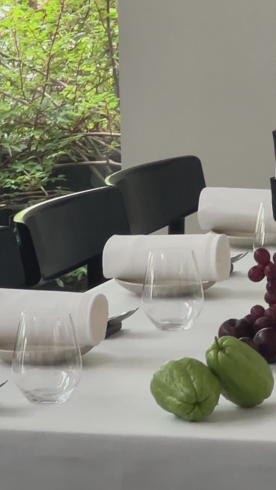 A table scape of flowers and fruits down the centre of the table